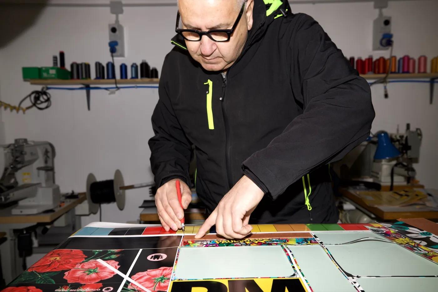 Paul bei der Arbeit in der Werkstatt von Paul Meccanico, bedrucktes Material von Hand zuschneidend
